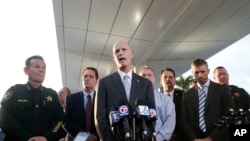 Bergabung dengan aparat penegak hukum, Gubernur Florida Rick Scott (tengah), berbicara dalam konferensi pers di luar Bandar Udara Internasional Hollywood-Fort Lauderdale, Florida, Jumat, 6 Januari, 2017.