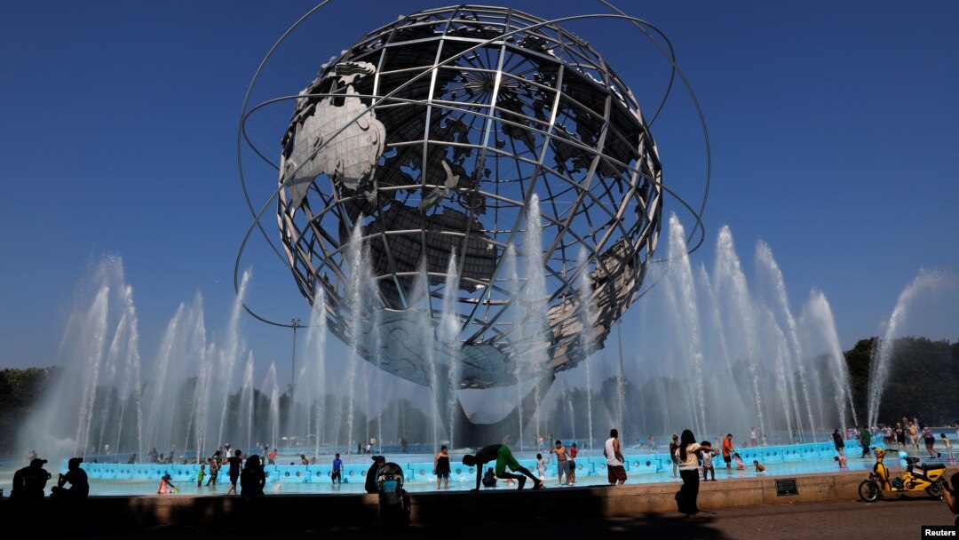 Warga berkumpul di kolam air mancur Unisphere untuk mendinginkan badan, di Queens, New York, 2 Juli 2019. 