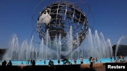 Warga berkumpul di kolam air mancur Unisphere untuk mendinginkan badan, di Queens, New York, 2 Juli 2019. 