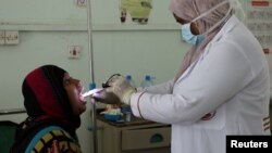 Nahla Arishi, a pediatrician, checks a woman infected with diphtheria at the al-Sadaqa teaching hospital in the southern port city of Aden, Yemen, Dec. 18, 2017. 