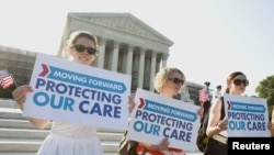 Supporters of the Affordable Healthcare Act gather in front of the Supreme Court before the court's announcement of the legality of the law in Washington, June 28, 2012. 