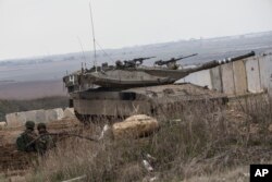 An Israeli tank and soldiers take up positions on the border between Israel and Gaza on November 16, 2018.