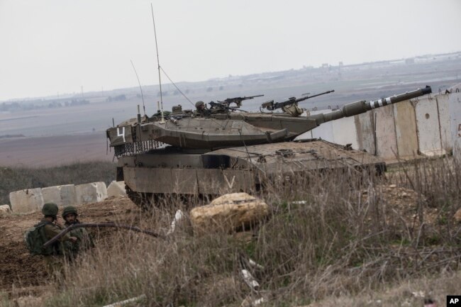 An Israeli tank and soldiers take positions on the Israel-Gaza border, Nov. 16, 2018.