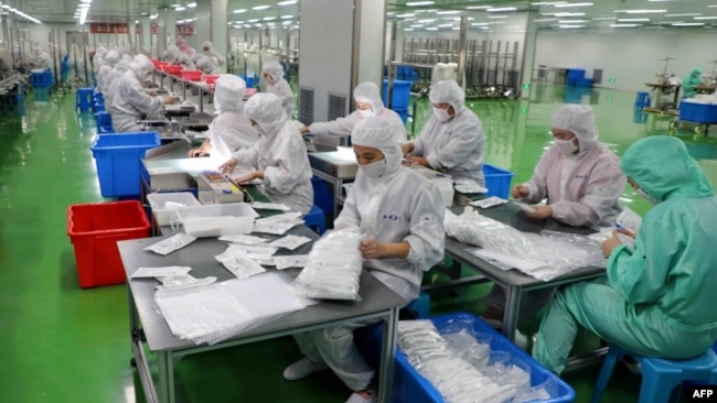 山东省滨州一家生产防护服的工厂工人在生产线上工作。（2020年2月13日）