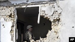 A US soldier checks the damage at offices of the U.N.'s refugee agency, the UNHCR, caused by a suicide bomber, in Kandahar, Afghanistan. A suicide vehicle bomb struck a checkpoint in a neighborhood housing United Nations and international aid groups' offi