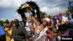 Marchers, including Jennifer Jones, center, mark the 10th anniversary of Hurricane Katrina by taking part in a remembrance and parade through the Lower Ninth Ward in New Orleans, Aug. 29, 2015. 