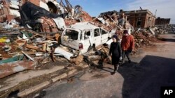 Warga memeriksa kerusakan di permukiman mereka pasca tornado melanda Mayfield, Kentucky (11/12). 