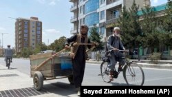 Sal Mohammad, 25 ans, un Afghan qui ramasse des morceaux de fer dans la rue pour les vendre à la ferraille, pousse sa charrette à bras à Kaboul, en Afghanistan, le mardi 31 août 2021.