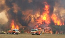 FILE - Firefighters try to protect homes around Charmhaven, New South Wales, in this image dated Dec. 30, 2019, and provided by NSW Rural Fire Service via their twitter account.