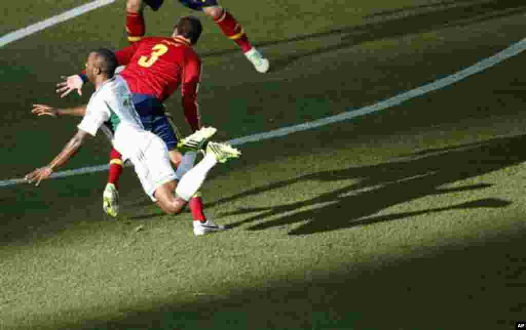 Nigeria's Sunday Mba, left, is airborne after colliding with Spain's Gerard Pique.