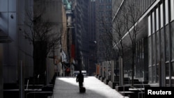 A man walks alone near the World Trade Center in lower Manhattan during the outbreak of the coronavirus disease in New York City, New York, March 27, 2020.