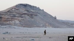 FILE - A Somali government soldier walks in Eyl, in Somalia's northeastern region of Puntland. U.S. airstrikes reportedly targeted members of a pro-Islamic State militants group in a remote mountainous part of the region.