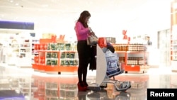 FILE - A woman from China at a duty-free store that offers new Mandarin-speaking personal shopper service at the airport in Frankfurt, Germany, Nov. 14, 2012.