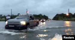 Cars drive through a flooded road in Mobile, Alabama, U.S., October 8, 2017, in this still image taken from a video obtained from social media. Michael Schubert/social media/via REUTERS