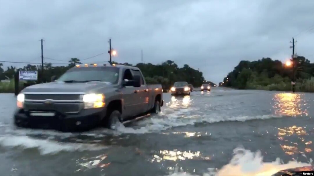 Cars drive through a flooded road in Mobile, Alabama, U.S., October 8, 2017, in this still image taken from a video obtained from social media. Michael Schubert/social media/via Reuters. 