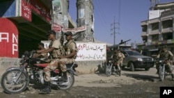 Pakistani paramilitary troops patrol on a street to ensure security in Karachi, Pakistan on Sunday, Oct. 16, 2010. Gunmen have killed at least 21 people in Karachi in the past 24 hours, raising tensions in Pakistan's largest city as voters headed to the p