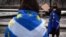 An anti-Brexit pro-Scottish independence activist wrapped in an EU flag holds a placard during a small protest against Britain's exit from the European Union outside the Scottish Parliament in Edinburgh on Dec. 31, 2020.