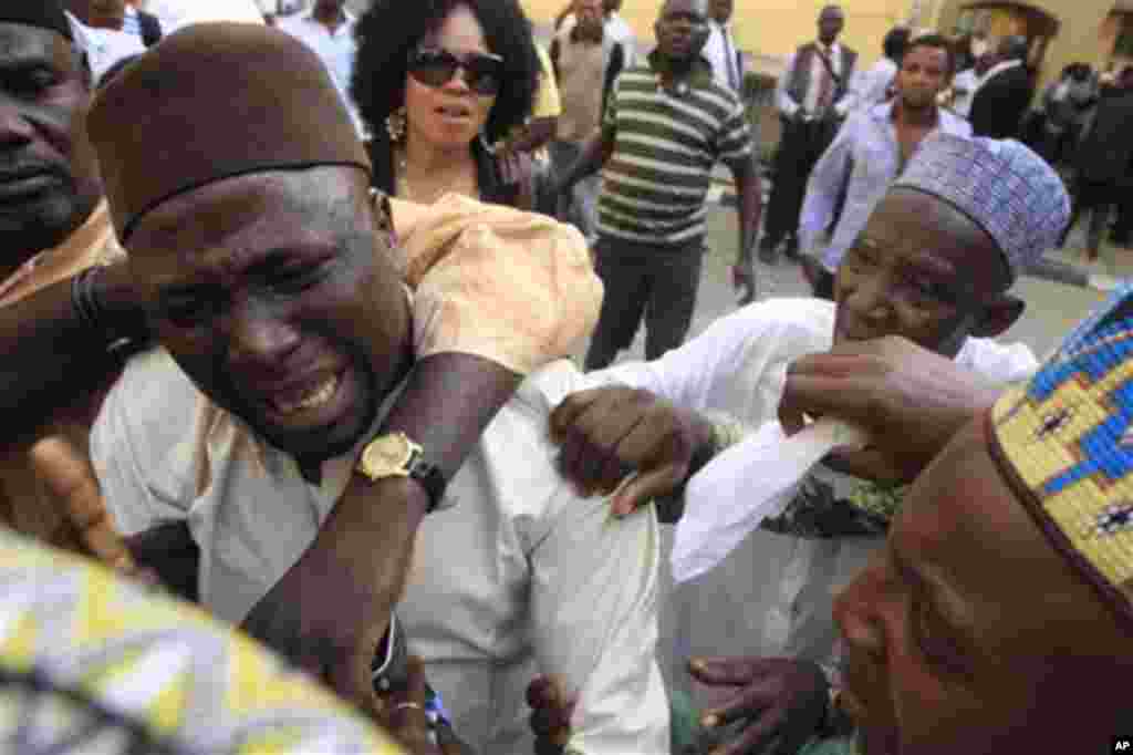 An unidentified family member of Maj. Hamza Al-Mustapha cries after a court Verdict in Lagos, Nigeria, on Monday, Jan. 30, 2012.