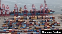 FILE PHOTO: Shipping containers are unloaded from a ship at a container terminal at the Port of Long Beach-Port of Los Angeles complex, amid the coronavirus disease (COVID-19) pandemic, in Los Angeles