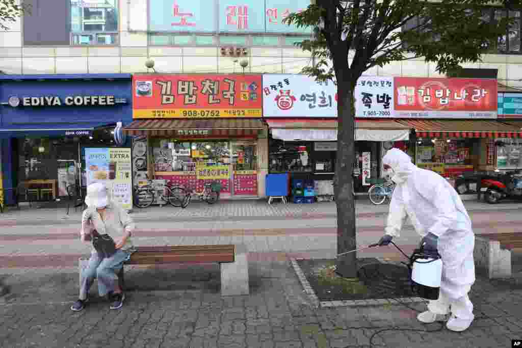 신종 코로나바이러스가 재확산되는 가운데 한국 고양에서 방역요원이 보도를 소독하고 있다. 