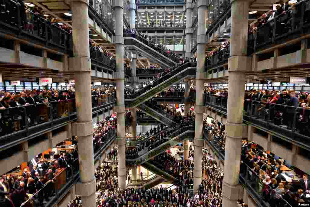 Workers stand during a Remembrance Service at the Lloyd&#39;s building in London.