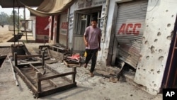 An Indian villager walks near damaged shops hit by mortar attack allegedly fired from the Pakistan’s side in Arnia Sector near the India-Pakistan international border, about 47 kilometers (30 miles) from Jammu, India, Oct. 7. 2014. 