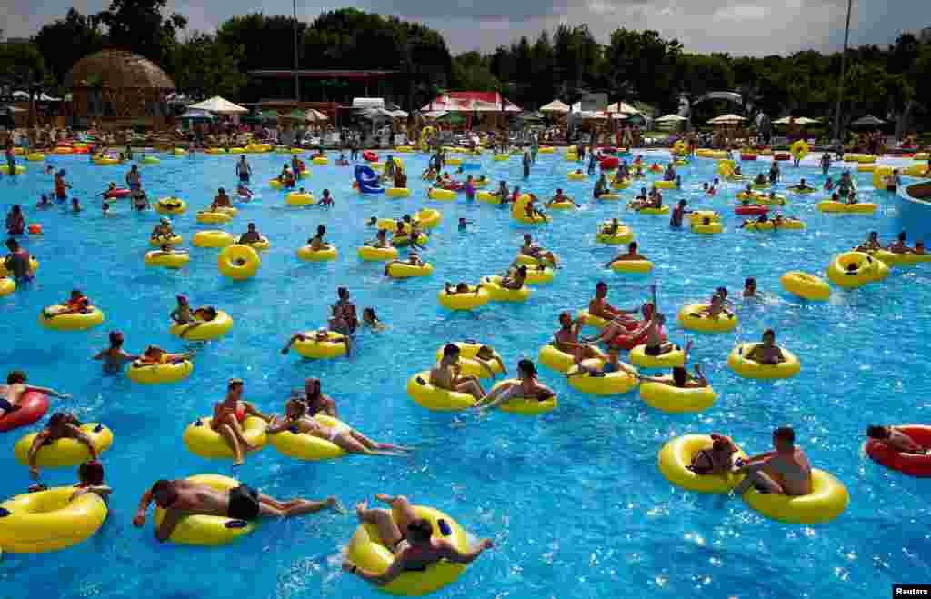 People cool down in water and amusement park &#39;Dreamland&#39; during a hot day in Minsk, Belarus, June 8, 2019.