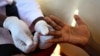 A doctor draws blood to check for HIV/AIDS at a mobile testing unit in a suburb of Uganda’s capital, Kampala, May 16, 2014.