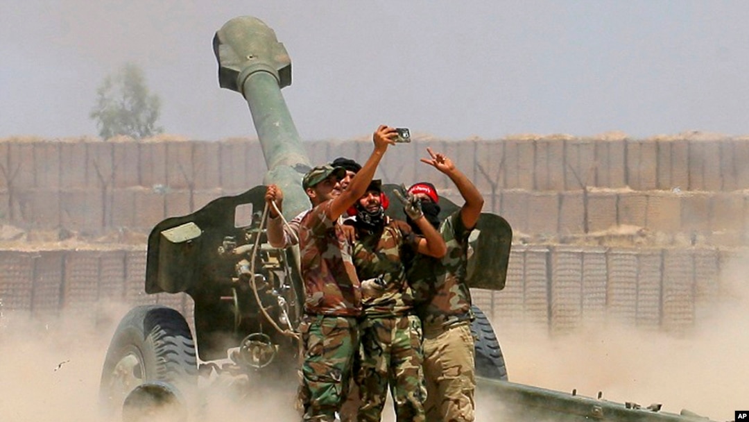 Fighters take a selfie while firing artillery against Islamic State militants in Fallujah, Iraq on Sunday, May 29, 2016.