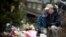 David Freedman, right, kneels with his son Zachary, 9, as they visit a sidewalk memorial for the 26 people, including 20 children, who were killed at Sandy Hook Elementary School in Newtown, Connecticut, December 16, 2013. 