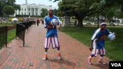 Cheese Chisholm y TooTall Hall, de los Harlem Globetrotters, jugaron y encantaron frente a la Casa Blanca el miércoles 29 de mayo. [Foto: Mitzi Macias, VOA].
