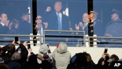 Trump saluda a los espectadores durante el descanso en el juego de fútbol americano entre el Ejército y la Armada, en Baltimore.