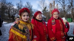 Women dressed in national suits celebrate Christmas in the village of Pirogovo outside capital Kyiv, Ukraine, Monday, Dec. 25, 2023. 