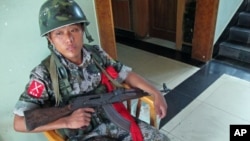 ທະຫານກອງທັບເພື່ອເອກະລາດຂອງກະຈິນ (Kachin Independence Army) ຜູ້ນຶ່ງ ນັ່ງຍາມຢູ່ໂຮງແຮມ Laiza Hotel, ບ່ອນທີ່ອົງການເອກະລາດຂອງຊົນເຜົ່າກະຈິນ ຈັດກອງປະຊຸມຂຶ້ນ ທີ່ເມືອງ Laiza, ມຽນມາ, ໃນເດືອນສິງຫາ 2011 ນີ້.