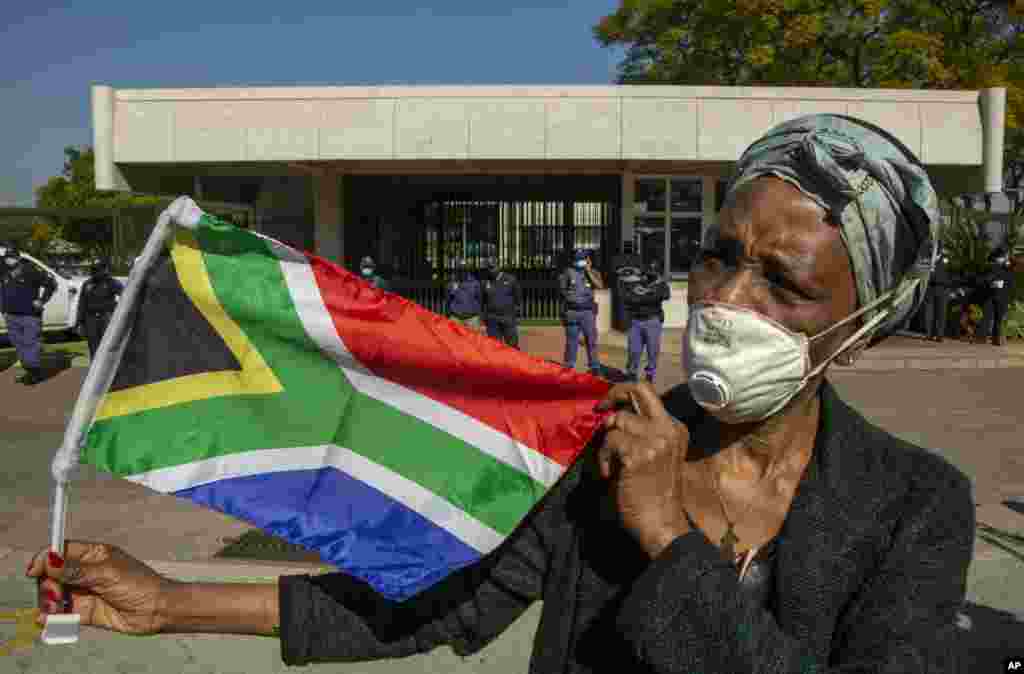 A woman holds a South African national flag during a protest against racism in front of the U.S. Embassy in Pretoria, South Africa, Friday, June 5, 2020.&nbsp;(AP Photo/Themba Hadebe)