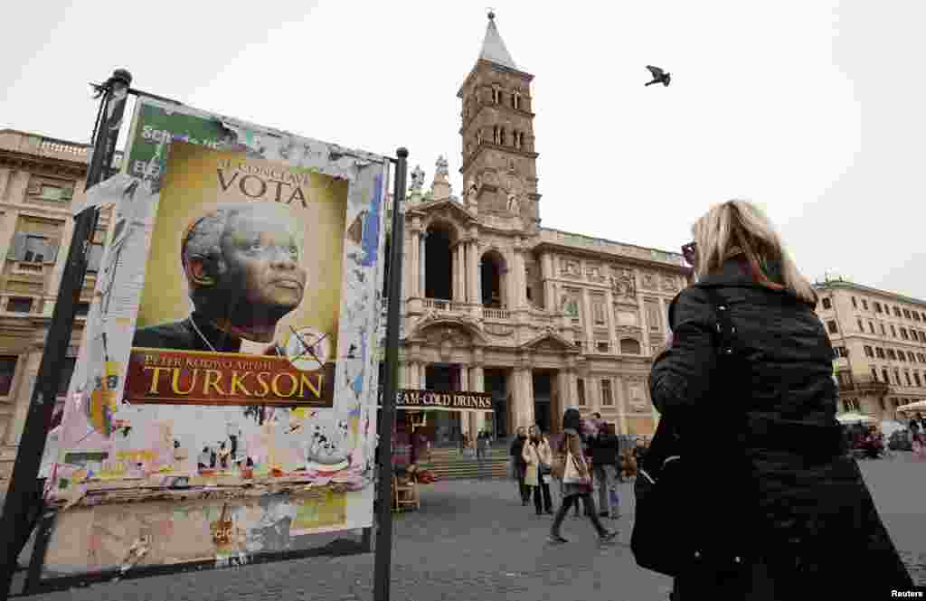 Now is the time for the next Roman Catholic Pope to come from Africa. - Black Christine from Yei A woman looks at a poster supporting Cardinal Peter Turkson of Ghana in front of the Papal Basilica of Saint Mary in Rome, March 1, 2013.(Reuters/Max Rossi)
