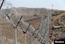 FILE - A view of the border fence outside the Kitton outpost on the border with Afghanistan in North Waziristan, Pakistan, Oct. 18, 2017.