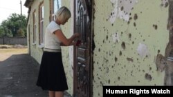A school principal outside Ilovaisk’s School Number 14. Due to the significant damage the school sustained during the conflict, it did not reopen for the 2015-2016 school year.