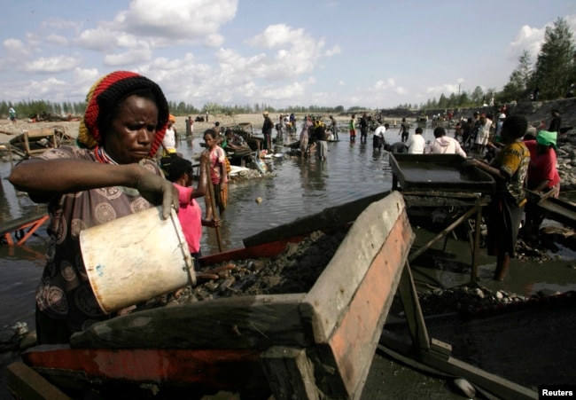 Penduduk desa berkumpul di sungai untuk mengolah lumpur yang mengandung emas, yang diambil dari pipa bocor milik tambang Tembaga & Emas Freeport McMoRan AS di desa Kwanki Lama di Papua. (Foto: Reuters)
