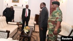 FILE: Zimbabwe's President Robert Mugabe meets with Father Fidelis Mukonori, Secretary to the Cabinet Dr Misheck Sibanda and Defense Forces Commander General Constantino Chiwenga at State House in Harare, Nov. 19, 2017.