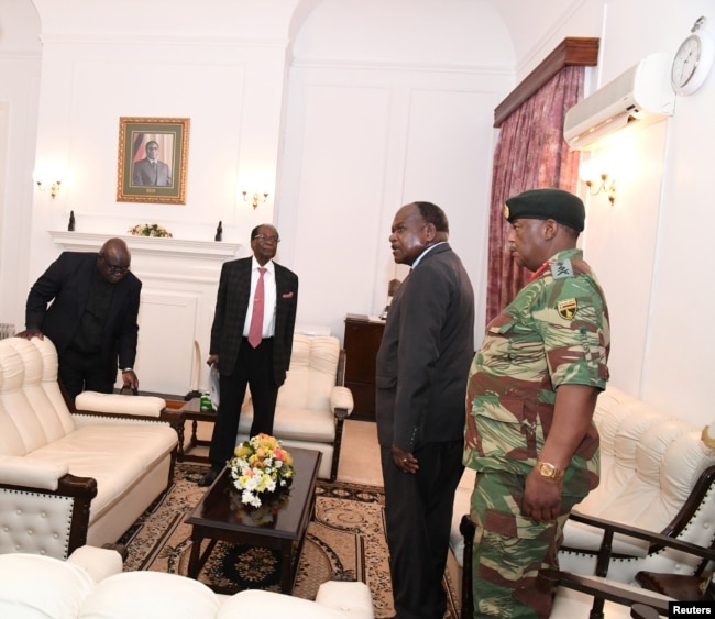 FILE - Mugabe meets with Father Fidelis Mukonori, Secretary to the Cabinet Dr Misheck Sibanda and Defense Forces Commander General Constantino Chiwenga at State House in Harare, Nov. 19, 2017.