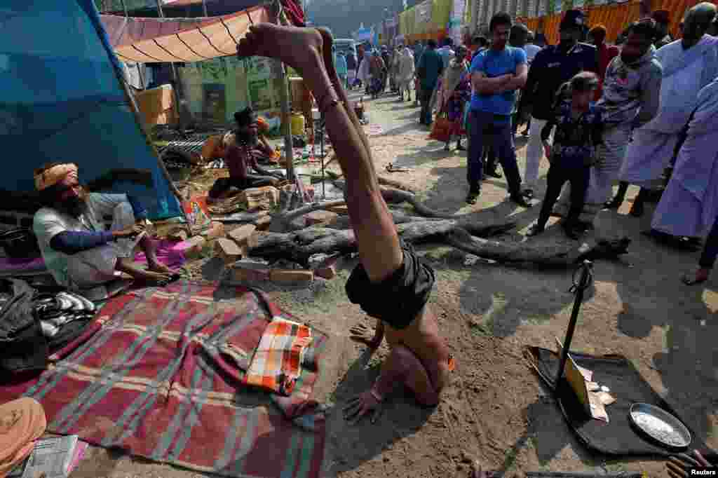 A Sadhu or a Hindu holy man performs to receive money from pilgrims at a makeshift shelter in Kolkata, India.