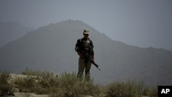 A Pakistani army soldier stands guards on a hilltop post in Hadambar, in Pakistan's Mohmand tribal region along the Afghan border, June 1, 2011.