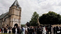 Muslim worshipers gather in front of the memorial at the Saint Etienne church, in Saint-Etienne-du-Rouvray, Normandy, France, July 29, 2016. 