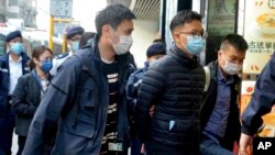 Editor of Stand News Patrick Lam, center, is arrested by police officers in Hong Kong, Dec. 29, 2021. 