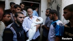 20일 이스라엘의 공습으로 하마스 지도자 무함마드 데이프 아내의 친척과 그의 갓난 아들가 사망한 것으로 알려졌다. 한 남성이 사망한 아기의 시신을 안고 있다.