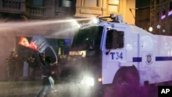 Turkish riot police fire water cannons and tear gas at hundreds of demonstrators who are trying to march to the city's main Taksim Square in Istanbul, Turkey, Saturday, Feb. 8, 2014.