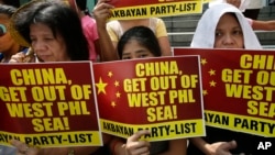 FILE - Protesters picket the Chinese Consulate at the financial district of Makati city east of Manila, Philippines, March 3, 2014.