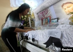 FILE - A woman pays her respects to slain transgender Jennifer Laude inside a funeral home in Olongapo city, north of Manila, Oct. 21, 2014.