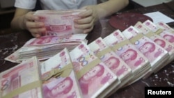 An employee counts Chinese 100 yuan banknotes at a branch of Bank of Communications in Shenyang, Liaoning province July 6, 2012.